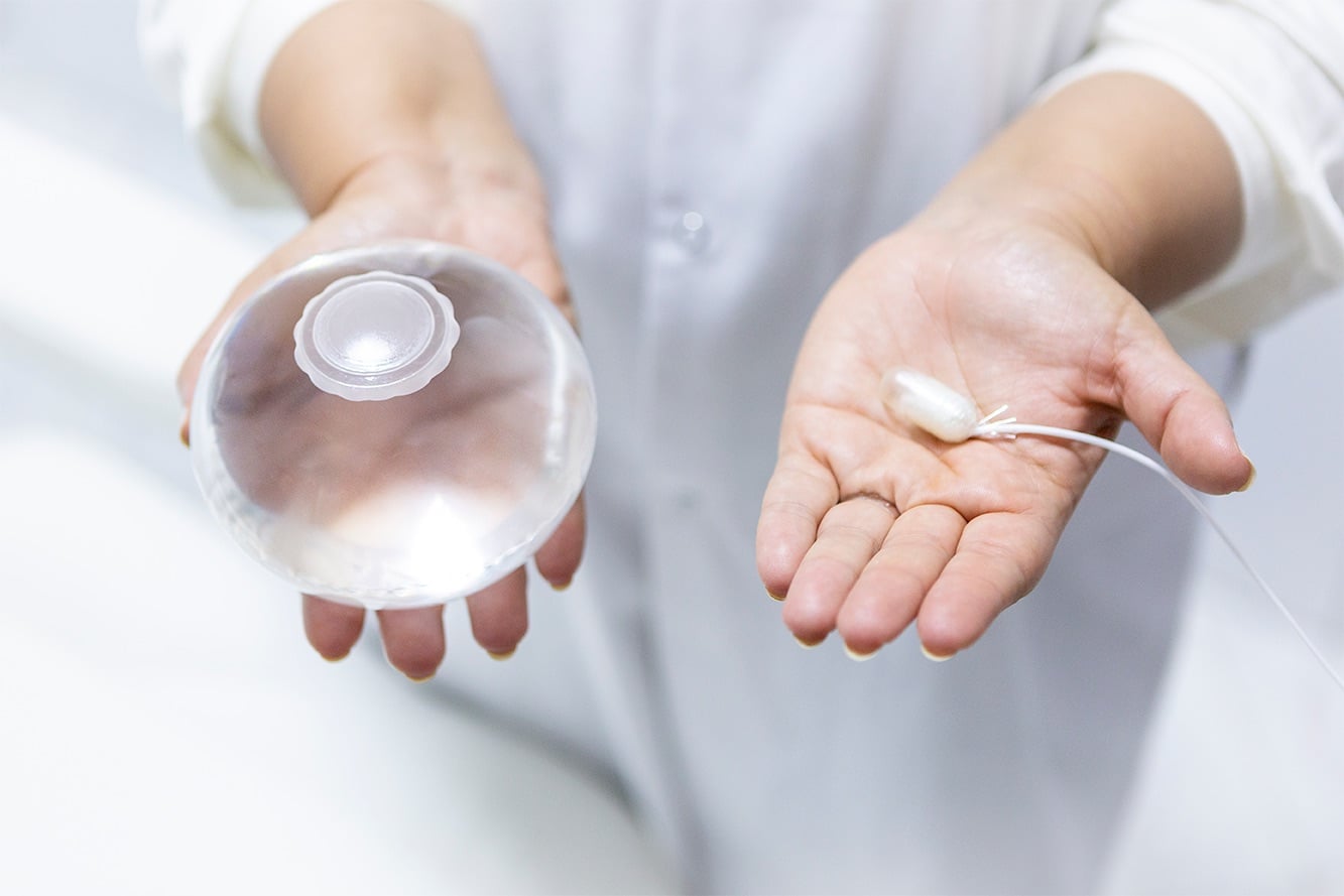 Allurion Smart Capsule and inflated gastric balloon, held by a clinician